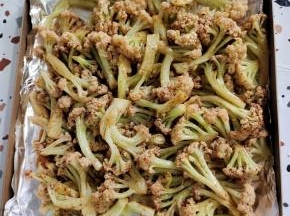 烤盘铺一层锡纸，把抓拌好的花菜倒在烤盘里！