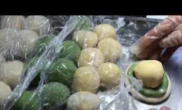 取第一个揉的白色面团按扁，再取第一个揉好的绿面团按扁，放入白色上面，再取第一个揉好的黄色面团放在绿色上面