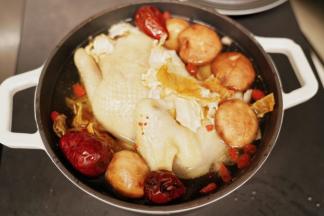 把老母鸡放入珐琅铸铁锅里，把洗净的枸杞、红枣、洋参和花胶也一起放入，加入适量的清水