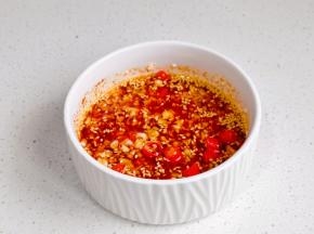 蒜末，辣椒段，白芝麻，辣椒粉放入碗中，泼热油拌均匀。