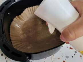 空气炸锅里放入一张油纸盘或者锡纸盘。用喷油壶喷适量的油！