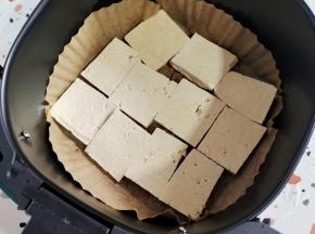 均匀的把豆腐平铺在油纸盘里！