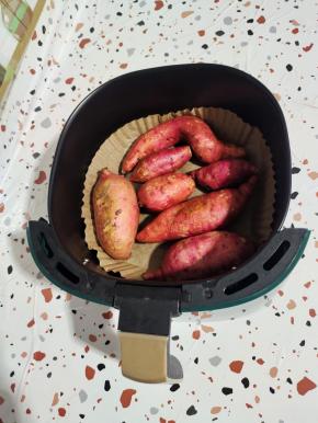 空气炸锅里铺一张油纸盘，把清洗干净的红薯摆放在里面！