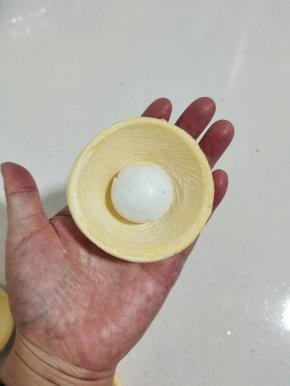 取一个蛋挞皮，放入一颗汤圆！