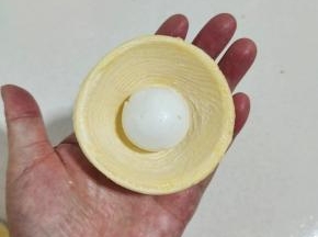 取一个蛋挞皮，放入一颗汤圆！
