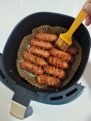 烤好的烤肠取出来，均匀的刷一层烧烤料汁儿！