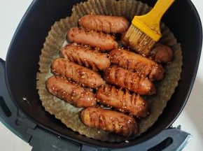 烤好的烤肠取出来，均匀的刷一层烧烤料汁儿！