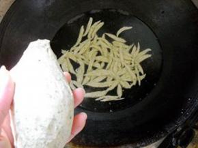 锅中烧开水；水开后，用剪刀将面团剪成小鱼状，下入锅中（有人帮着拍照就直接向开水中剪入面条）。
