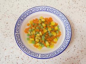 胡萝卜切成丁，和玉米粒、豌豆一起焯水，捞出过凉水。