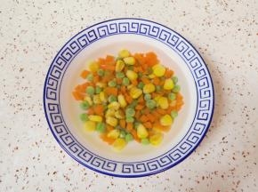 胡萝卜切成丁，和玉米粒、豌豆一起焯水，捞出过凉水。