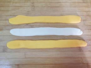 面团也饧好了，取同等份的黄色面团2份，白色面团1份，分别搓成长条状压扁。