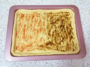 饼底一边抹上一层番茄酱，一边抹上一层黑胡椒酱。