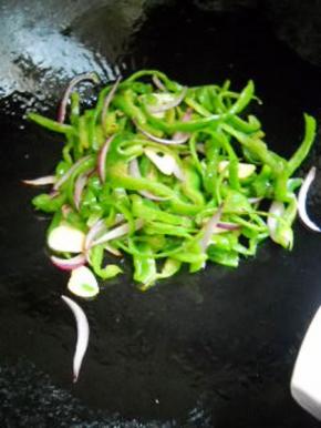 下入青椒，加少许盐，炒匀。