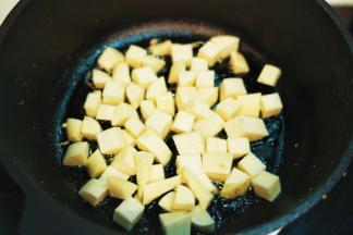 热油锅后放入切小方粒的茭白煸炒出香味