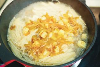 倒入炒香的茭白、榨菜丝和过桥米线一起煮