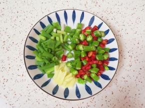 青椒、红椒和小葱分别切成小段，生姜切成丝。