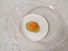 牛奶倒入盆里，打入一个鸡蛋加入盐。