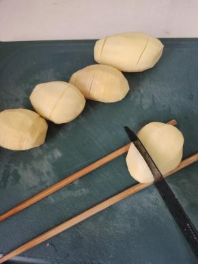 土豆削皮清洗干净，下面垫一双筷子，切片不要切断！