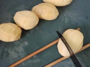 土豆削皮清洗干净，下面垫一双筷子，切片不要切断！