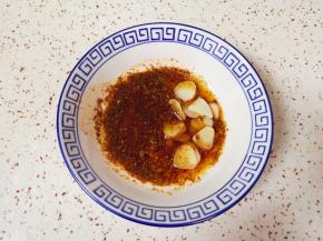 炒锅内倒适量的菜籽油烧热，浇在蒜片和辣椒粉上面激出香味。