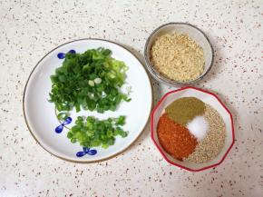 蒸土豆的时间里准备调味料:小葱切成葱花，准备好果仁，辣椒粉、孜然粉、熟白芝麻和盐混合均匀。