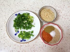 蒸土豆的时间里准备调味料:小葱切成葱花，准备好果仁，辣椒粉、孜然粉、熟白芝麻和盐混合均匀。
