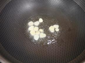 炒锅内倒适量的玉米油烧热，下入蒜片炒香。