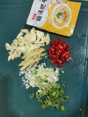 蒜瓣切成小块，生姜切成丝，葱切成葱花，小米辣切成小块，再准备两包酸汤肥牛调味料！