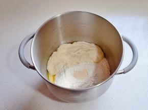 再加入奶粉，高粉，液种，酵母粉启动厨师机2档揉面至粗膜。