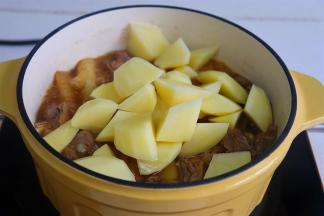 开盖，转为旺火，把土豆加入，用筷子搅拌，让汤汁进入食材，继续炖12分钟左右。