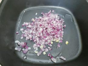 锅里加入植物油，油温升高后放入洋葱碎和大蒜末爆香