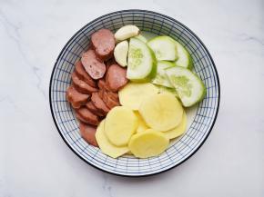 .土豆、黄瓜、红肠切片，大蒜去皮拍扁。