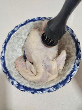 三黄鸡清洗干净，控干水分，用扎空工具在鸡表面均匀的扎几下，方便腌制入味儿！