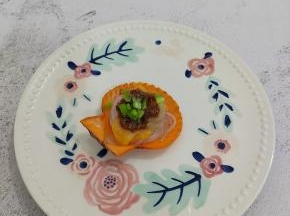 将炒好的蒜蓉连油一起平铺在扇贝，最后上面放上青椒碎