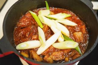 放入洗净切段的大葱翻炒均匀