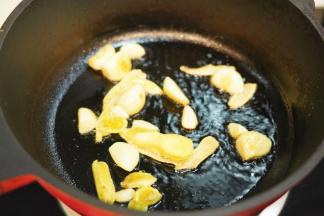 锅里热油后放入姜片和蒜瓣煸炒出香味