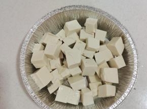 嫩豆腐切成小块放入锡纸盘中！