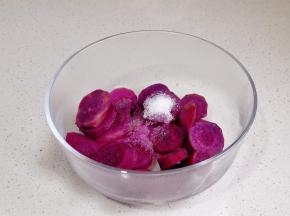 蒸熟的紫薯中加糖。