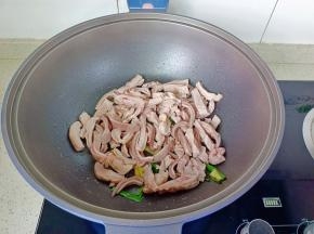热锅下姜片，葱段爆香，再放入猪肚条爆炒两分钟。