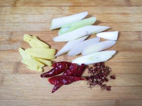 大葱切成段，生姜切成片，准备好干红辣椒和花椒。