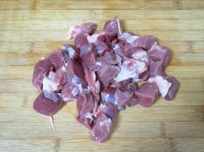 将用水泡过的羊肉切成块。