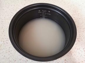 大米淘洗干净放入电压力锅饭煲内胆里面，加入纯净水。