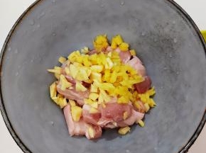 五花肉洗干净切片，把切好的五花肉放入碗中，加入姜蒜