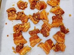 然后把腌制好的五花肉放在铺有油纸的烤盘上，放入提前预热好的烤箱中，中层190度20分钟即可取出
