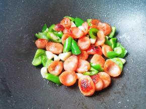 锅中热油爆香大蒜，放香肠青椒一起炒熟盛出备用。