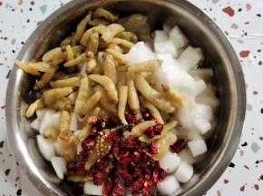 晾干水分的萝卜丁放入盆中，放入泡椒，小米辣(没有的可以用干红辣椒来代替！)，白糖，白醋，凉开水！(按照500克萝卜，放一袋泡椒，一把小米辣，白糖30克，白醋15克。凉开水半碗的比例来放！)