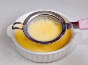 将蛋液过细筛到豆腐碗中。