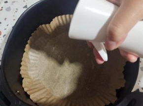 油纸盘放入空气炸锅里，底部用喷油壶喷少许油！