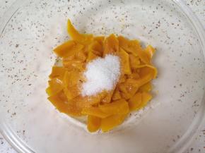 蒸好的南瓜片倒入盆里，加入细砂糖搅拌均匀。