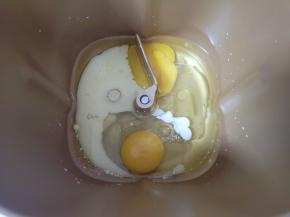 面包机桶内加入玉米油和牛奶，打入两个鸡蛋。